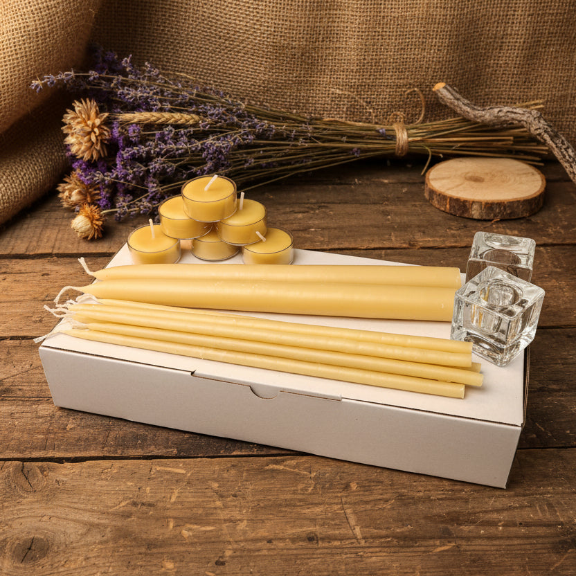 Set of beeswax candles and tealights on a white surface with a neutral background